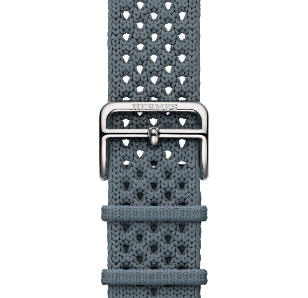 Apple Watch Hermès Series 11ネオ・トリコストラップ。カラーはブルー・グリ（ブルーグレイ）、ポリアミドのニット素材。中央に調節用の穴があり、Hermèsの刻印が入ったシルバーカラーのバックルが付いている